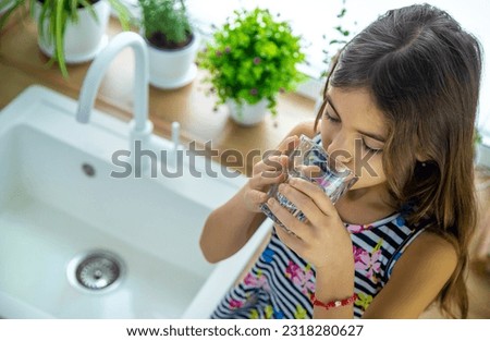 Children drink tap water at home. Selective focus.