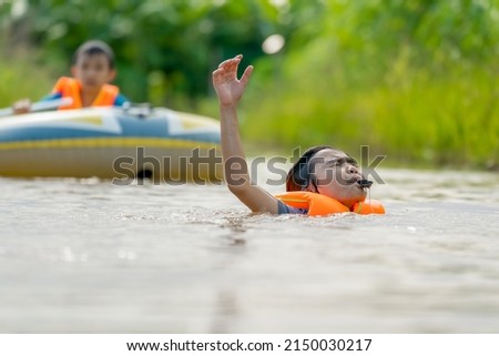 Children drowning the river and blowing whistle show sign for helping and save life 