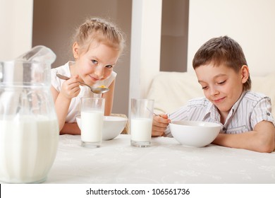 Children eat breakfast. Family eating cereals with milk