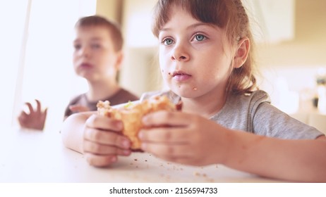 Children Eat Burgers. Fast Food Burger. A Group Of Small Children In The Kitchen Greedily Eat Fast Food Burgers. Big Sun Family Small Kids Having Breakfast In The Morning In The Kitchen Eating Burger