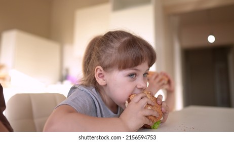 Children Eat Burgers. Fast Food Burger. A Group Of Small Children In The Kitchen Greedily Eat Fast Fun Food Burgers. Big Family Small Kids Having Breakfast In The Morning In The Kitchen Eating Burger