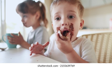 Children Eat Chocolate. Dirty Little Baby Kids In Lifestyle The Kitchen Eating Chocolate In The Morning. Happy Family Eating Sweets Kid Dream Concept. Baby Dirty Face Eating Chocolate Cocoa