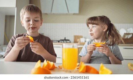 children eat oranges. happy family kid dream concept. drinking fresh juices. morning breakfast brother and sister lifestyle eat oranges in the kitchen. fruits orange juice healthy eating - Powered by Shutterstock