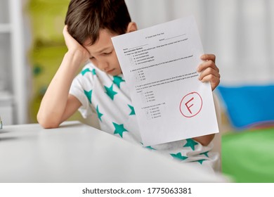 Children, Education And Learning Concept - Sad Student Boy With Failed School Test At Home