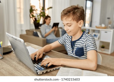 children, education and school concept - happy student boy with laptop computer learning at home - Powered by Shutterstock