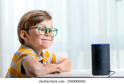 Children, Education And Technology Concept. Funny Pupil Boy Using Smart Speaker At Home While Doing Homework. Home Robot. Education Programme For Child