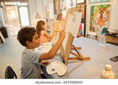 Children enjoying art class, painting and drawing with guidance from their teacher in a lively workshop. Engaged in creative activities, learning new artistic skills. - Powered by Shutterstock