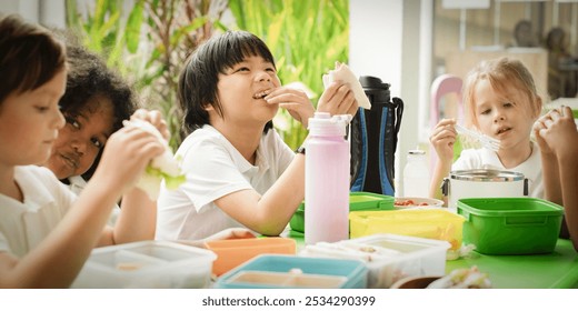 Children enjoying lunch together at a table. Kids eating sandwiches, smiling, and sharing food. Diverse group of children having a fun meal time. Diverse young students eating school lunch. - Powered by Shutterstock