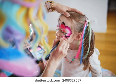 Children face painting. Artist painting little preschooler girl like unicorn on a birthday party. Creative activities for kids - Powered by Shutterstock