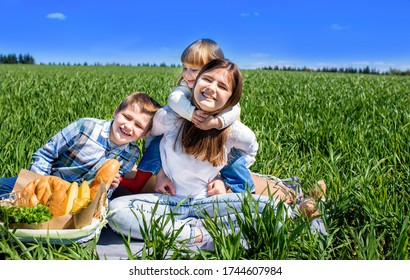 Kinder auf einem Feld auf einem Picknick. Brot und Obst in einem Korb. Sonniger Sommertag. Teenagermädchen 14 Jahre alt, Mädchen und Junge 7 Jahre alt lachen und spielen. glückliche Kindheit. Im Park im Freien.