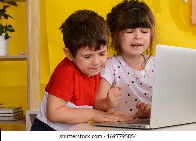 Children Fighting And Quarrelling For The Laptop. The Brother Wants The Notebook, His Sister Too.