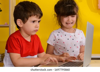 Children Fighting And Quarrelling For The Laptop. The Brother Wants The Notebook, His Sister Crying. 