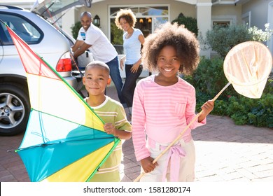 Children with fishing net and kite packing car for family trip - Powered by Shutterstock