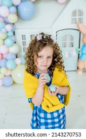 Children Girl In Bunny Ears Dye Colorful Egg For Easter Hunt. Home Decoration With Flowers, Basket And Rabbit For Spring Holiday Celebration.