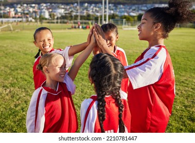 Children, Girl Football Team And High Five For Sports Group Motivation On A Soccer Field For Celebration Of Goal, Winning And Teamwork Outdoors. Junior Competition For Kids Diversity Tournament Match