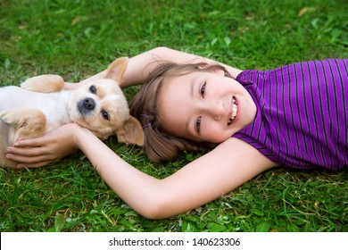 Children Girl Playing With Chihuahua Dog Lying On Backyard Lawn