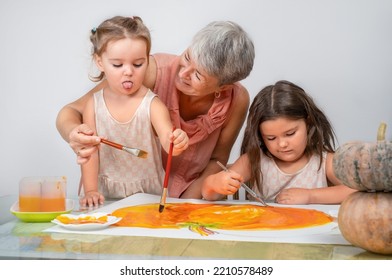 Children With Grandma Painting Halloween Pumpkin