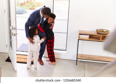 Children Greeting And Hugging Working Businessman Father As He Returns Home From Work - Powered by Shutterstock