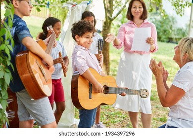 Children Group At The Talent Show Performance With Guitars In The Holiday Camp In Front Of An Audience