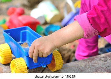 Children Hand Keep The Plastic Carriage Toy At Sandpit.