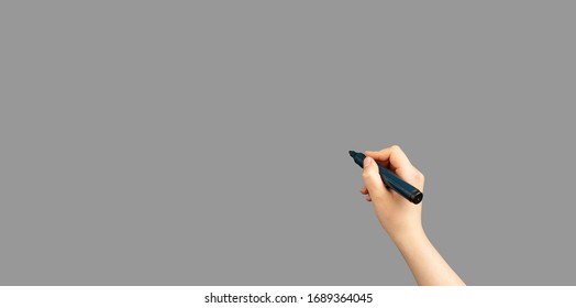 Children hand with marker write on an isolated grey background. Writing hand. Hand holding black Pen. - Powered by Shutterstock