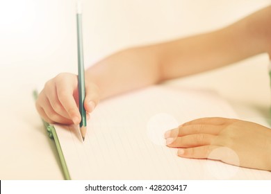 Children Hand With Pencil Writing On Notebook