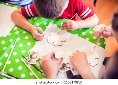 Children Hands Making Artworks With Wood And Paint Crafts. Workplace And Handcraft Decoupage