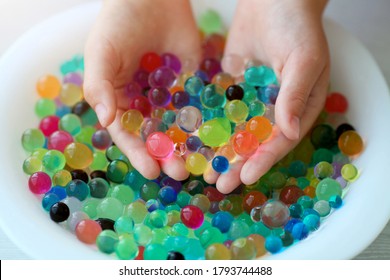 Children is hands play orbeez in a plate. Decoration with water balls hydrogel - orbeez.