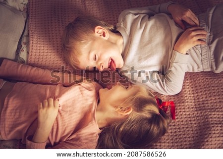 Similar – Little girl playing over boy lying in the bed