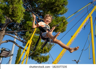 Children have fun jumping on bungee trampoline secured with rubber bands.  - Powered by Shutterstock