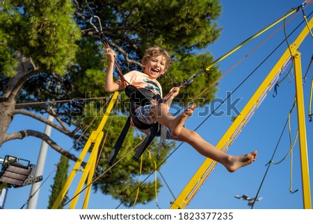 Similar – Image, Stock Photo Bungee jumping at trampoline. Little girl bouncing on bungee jumping in amusement park on summer vacations