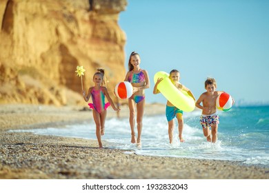 Children Have Fun On The Sandy Beach In Summer. High Quality Photo.