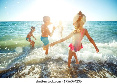 Children Have Fun On The Sandy Beach In Summer. High Quality Photo.