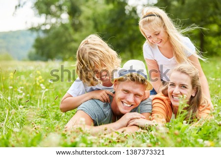 Children have fun playing with their parents on a summer meadow