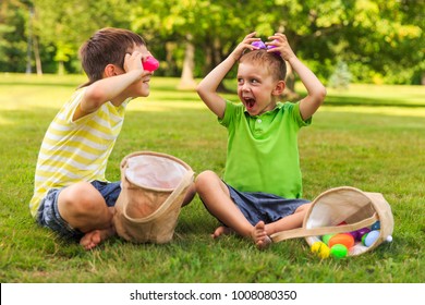 children having fun and playing with easter eggs. two cheerful boys sit on the lawn after Easter eggs hunt - Powered by Shutterstock