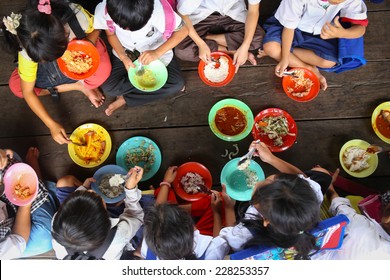 Children Having Lunch In Asian School Sitting On The Floor