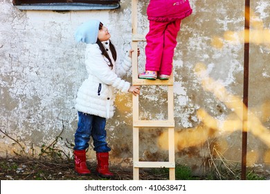 Children help each other to climb the ladder.