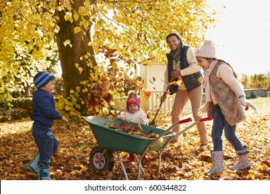 Children Helping Father To Collect Autumn Leaves In Garden - Powered by Shutterstock