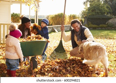 Children Helping Parents To Collect Autumn Leaves In Garden - Powered by Shutterstock