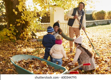 Children Helping Parents To Collect Autumn Leaves In Garden - Powered by Shutterstock