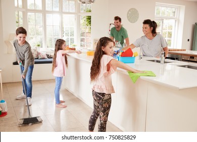 Children Helping Parents With Household Chores In Kitchen