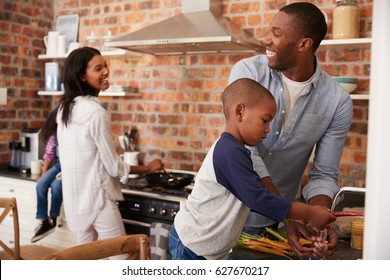 Children Helping Parents To Prepare Meal In Kitchen - Powered by Shutterstock