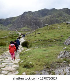 Children Hiking On A Stone Pathway With Mountains In The Background, Snowdonia National Park, North Wales, United Kingdom.