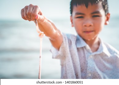Children is holding Plastic straw that he found on the beach, For Plastic Trash and pollution activism recycle concept.