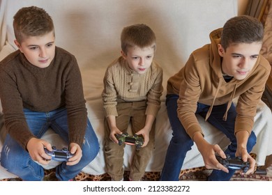 children with joysticks in their hands play games - Shutterstock ID 2123382272