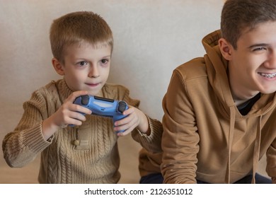 children with joysticks in their hands play games - Shutterstock ID 2126351012