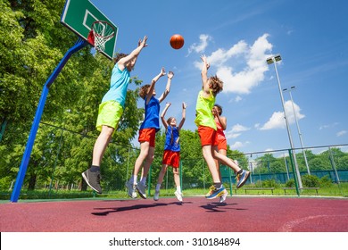 Children jump for flying ball during basketball