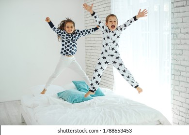 Children Jump On The Bed.The Boy And The Girl Are Having Fun. High Quality Photo. 