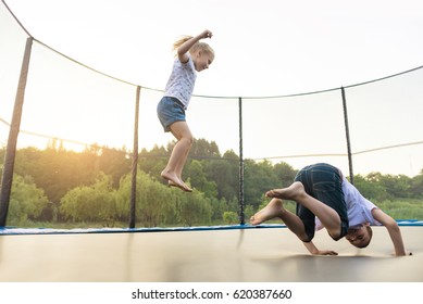 Children jumping on a trampoline in a park without parental supervision