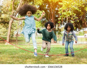 Children jumping over the rope in the park